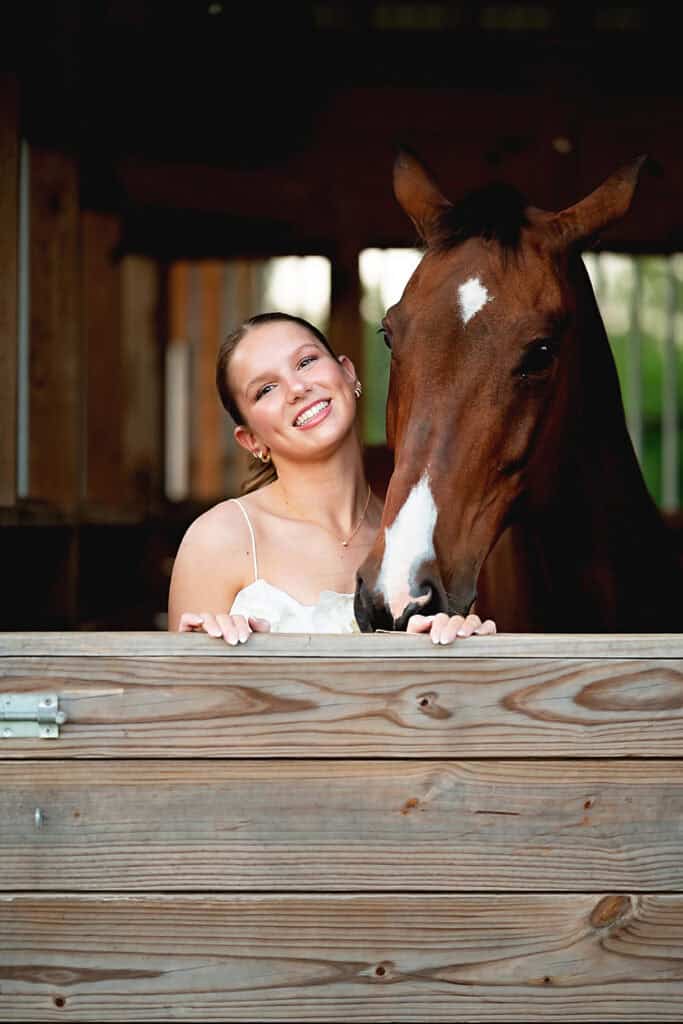 horse and senior girl in a barn